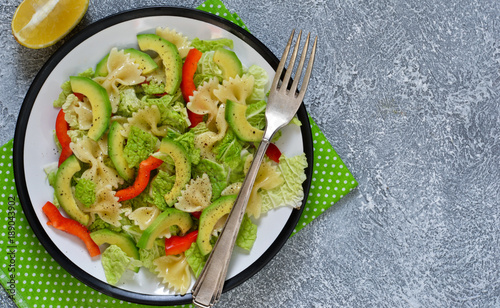 Vegetable salad with china, avocado and pepper on a concrete background.