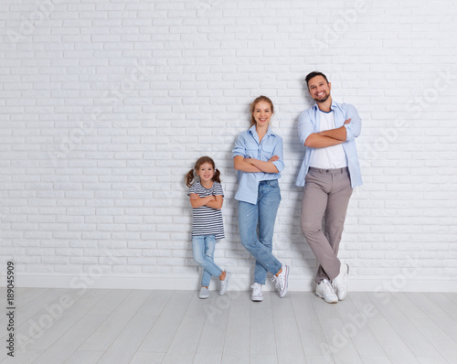 happy family mother father and child near an empty brick wall