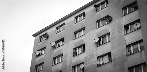 Mehrstöckiges Wohnhaus mit Satellitenschüsseln, schwarz weiß