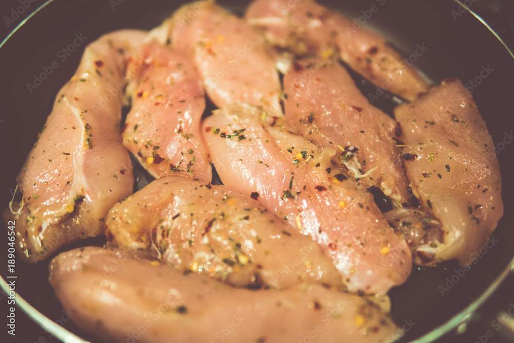 chicken breasts in a frying pan with seasoning chicken breasts in a frying pan with seasoning