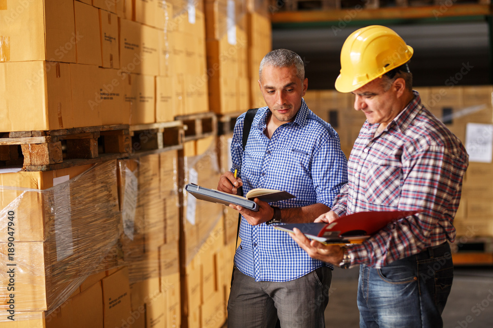 Manager and warehouse worker checking list and inventory on the shelf in storehouse. Manager and warehouse worker checking list and inventory on the shelf in storehouse.