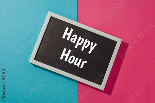 Happy hour - text on chalkboard on blue and pink bright background.