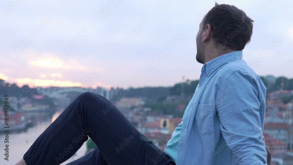 Young man admire view of Porto in Portugal sitting on ledge
Young man admire view of Porto in Portugal sitting on ledge
