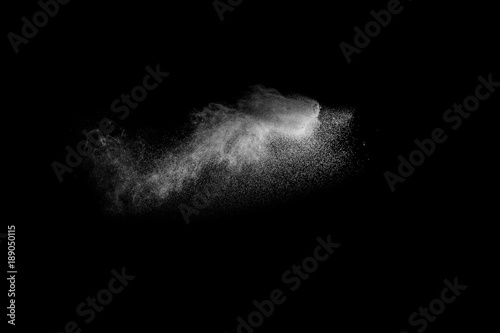 Freeze motion of white particles on black background. White granule explosion. Abstract white dust overlay texture.