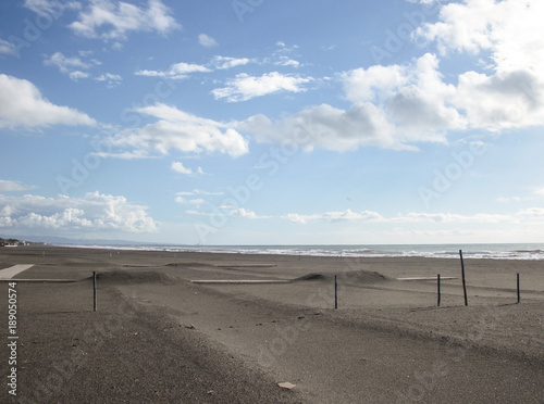 Spiaggia nera di Montalto di Castro con paletti nella sabbia