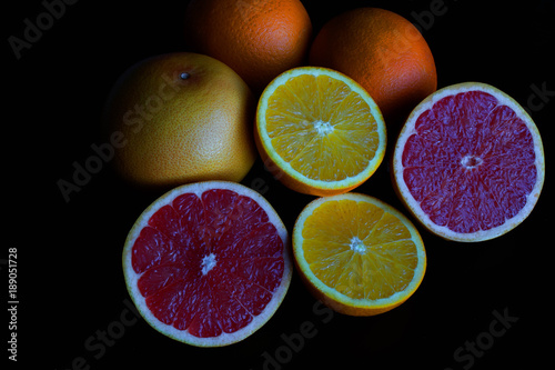 Background with citrus fruit slices on black table