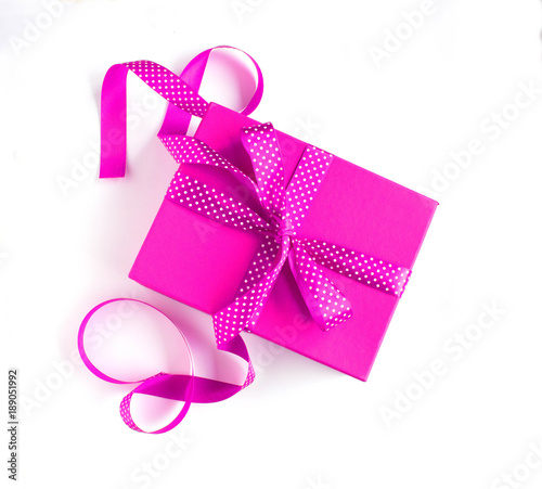 Pink gift box with pink dotted ribbon isolated on white