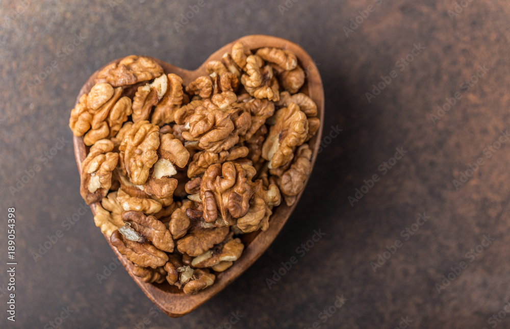 Fototapeta premium Walnuts. Walnut kernels and whole walnuts on rustic table. 