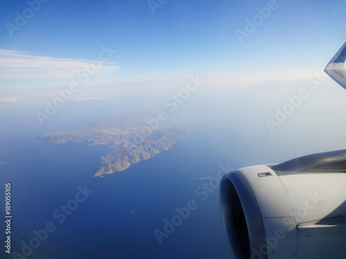 Beautiful scene of blue sky and island from airplane window