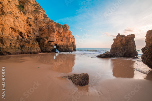 beautiful Atlantic ocean view horizon with sandy beach, rocks and waves at sunrise. Algarve, Portugal © savantermedia