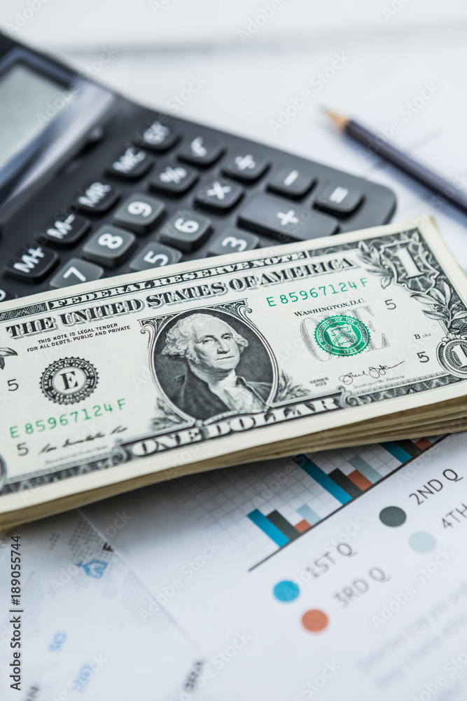 Calculator with american dollars on the wooden table background, finance concept Calculator with american dollars on the wooden table background, finance concept