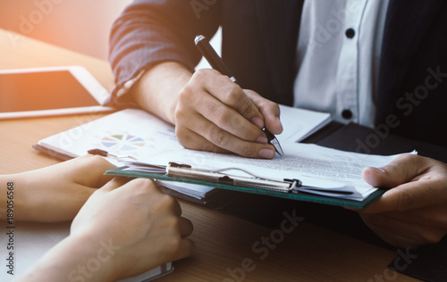 Business man is signing a business deal with secretary hand on the table