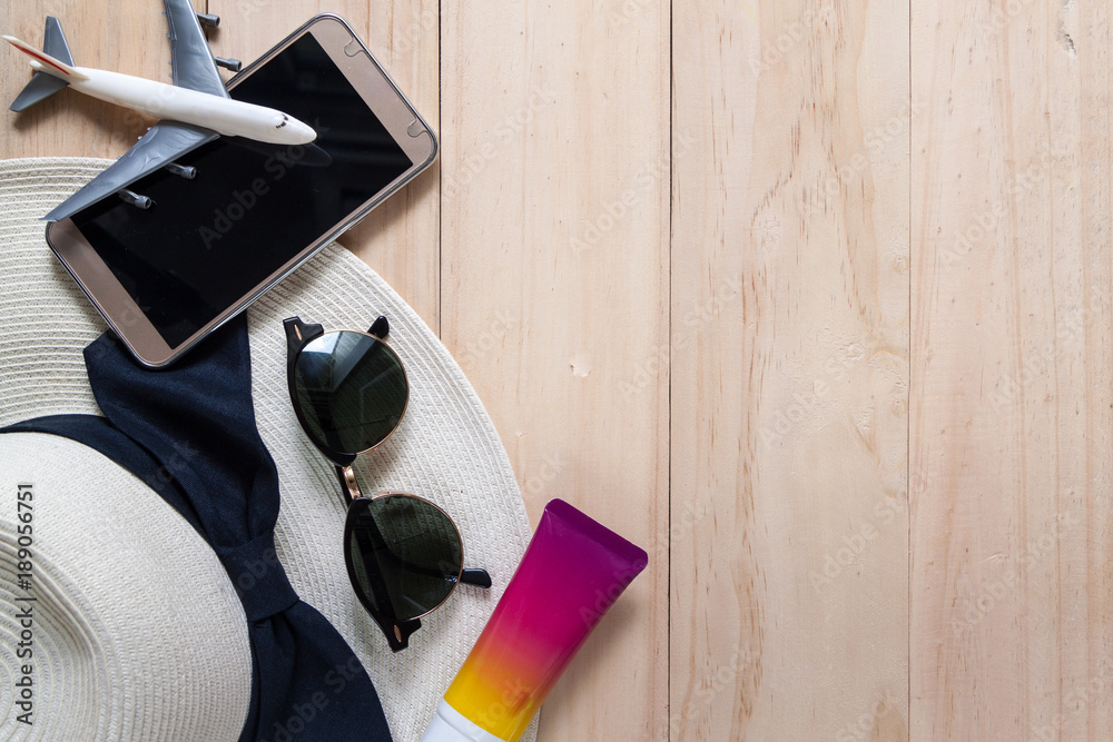 Top view of travelling items in summer season on wooden background, holiday and travel concept Top view of travelling items in summer season on wooden background, holiday and travel concept
