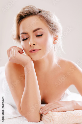 Young  beautiful and healthy woman relaxing in spa salon. Rejuvenation therapy and massaging treatments. Recreation concept.