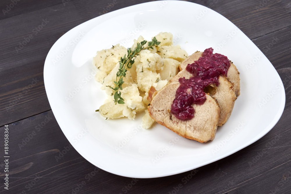 Pieces of meat in sauce with potatoes on a white plate Pieces of meat in sauce with potatoes on a white plate