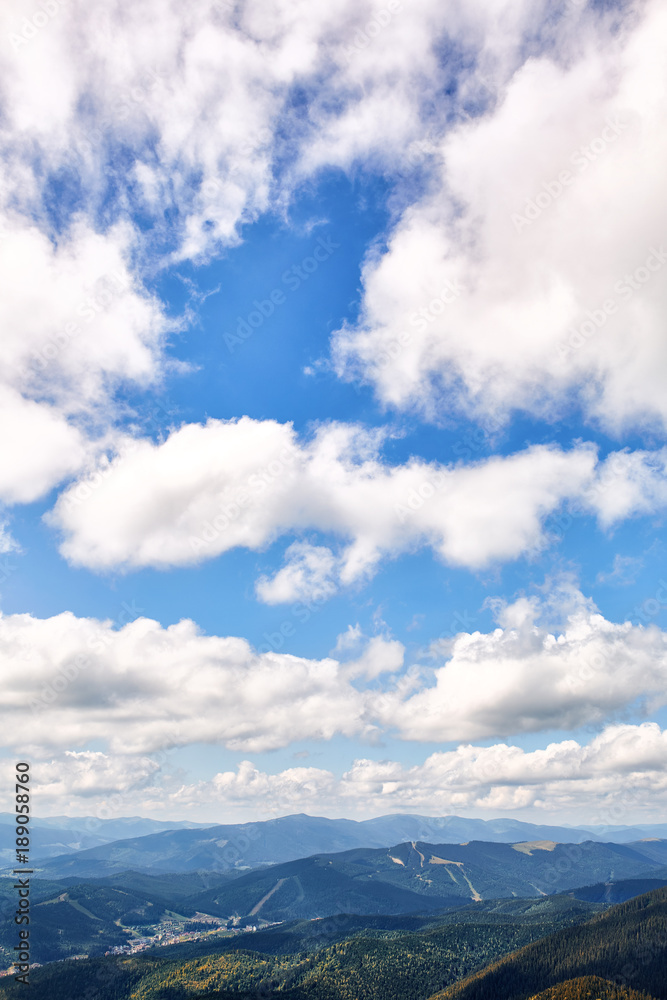 Blue sky and mountain background with white cloud, white fluffy clouds in the blue sky. Vertical