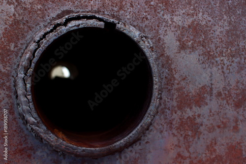 Background with a circular hole on a rusty metal surface