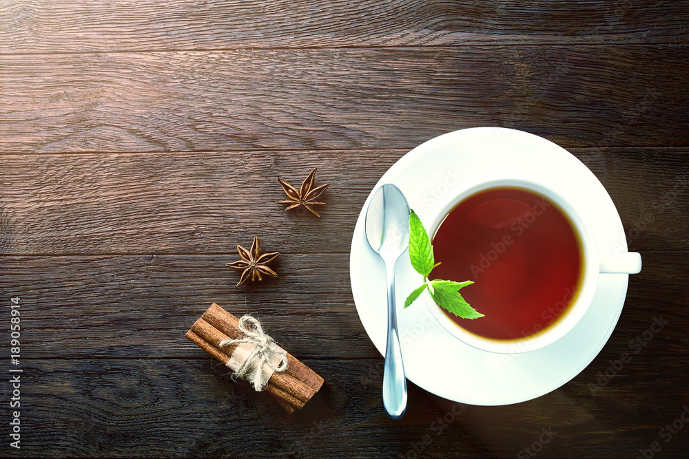 Overhead view of a cup of tea with cinnamom, mint leaves and fruits of star anise. Overhead view of a cup of tea with cinnamom, mint leaves and fruits of star anise.