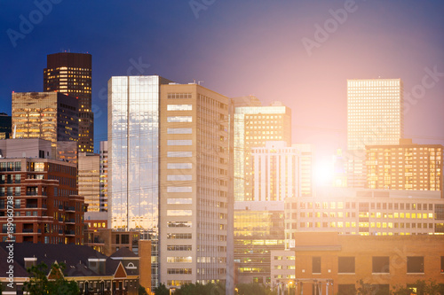 Denver Colorado downtown skyline buildings with the warm glow of sunlight shining through the skyscrapers