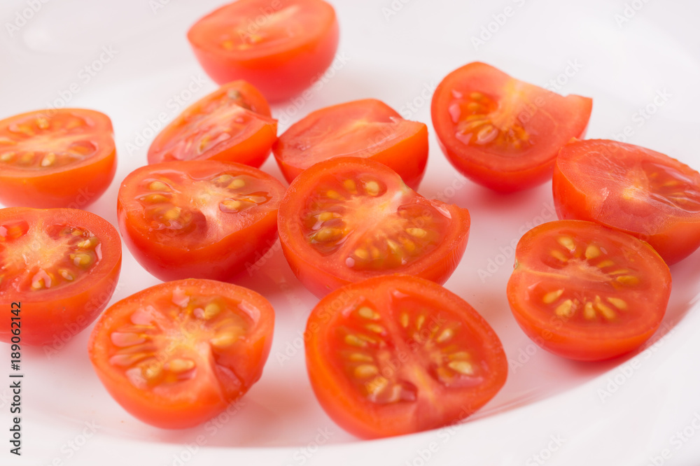 Sliced cherry tomatoes on a white plate Sliced cherry tomatoes on a white plate