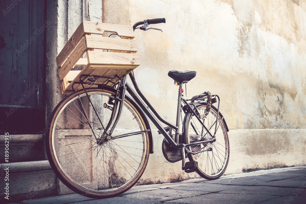 vintage bicycle with wooden crate, bike leaning on a wall in italian street