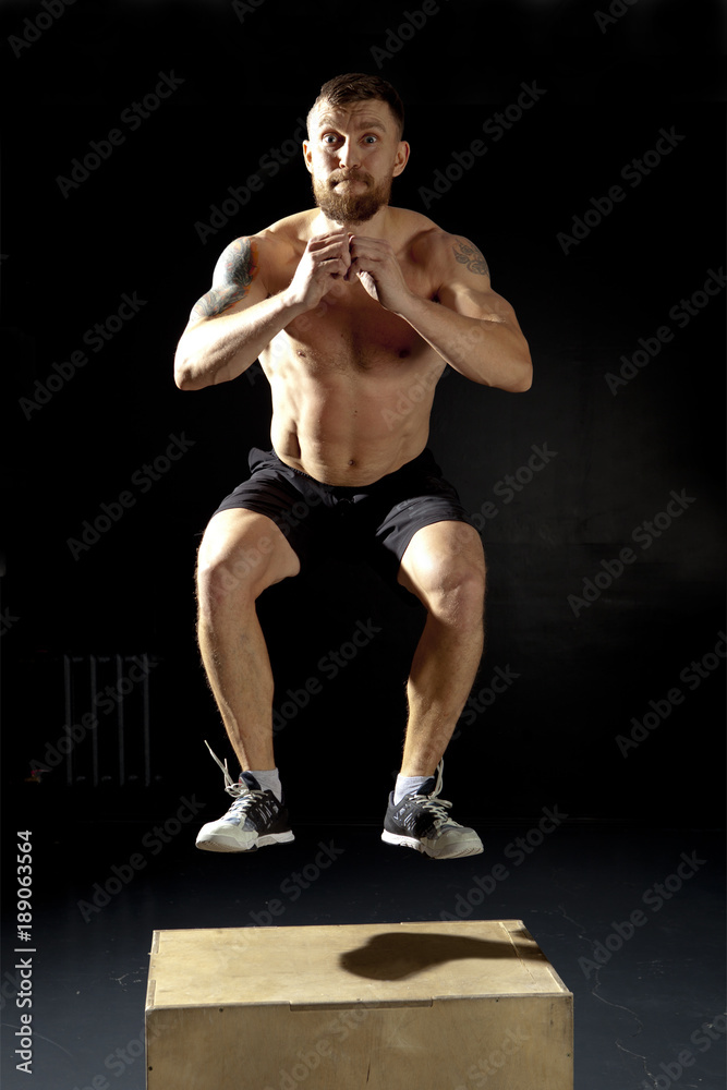 Man jumping on fit box in gym Man jumping on fit box in gym