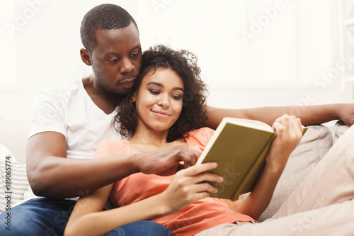 HAppy black couple reading together at home