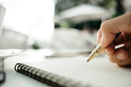 business background hand of businessman with pen write on blank notebook paper. image for education, diary, document, body, object, copy space, workplace concept