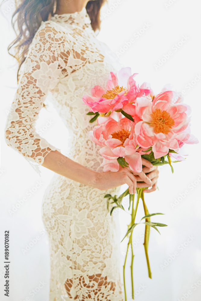 Beautiful young woman with pink peony