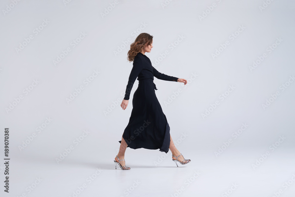Woman wearing long black dress walking