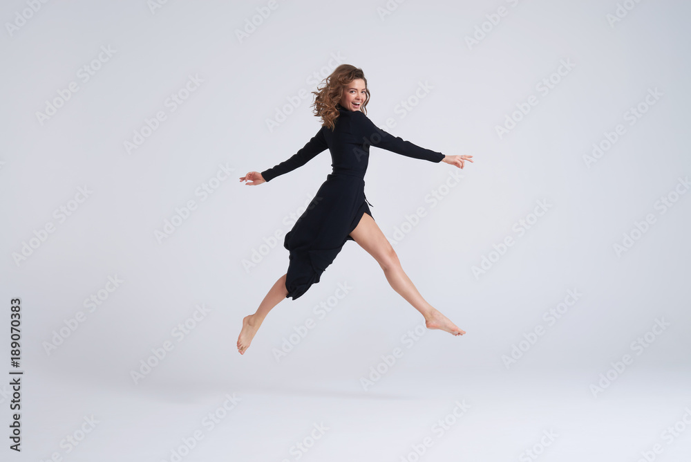 Jumping woman in black dress