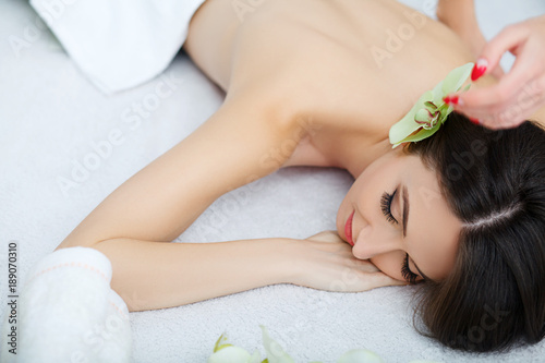 Young female lying in spa salon after procedure of body massage