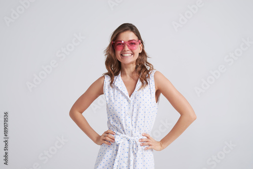 Smiling beautiful girl in pink glasses posing