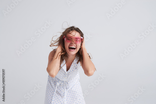 Excited girl in pink sunglasses going crazy