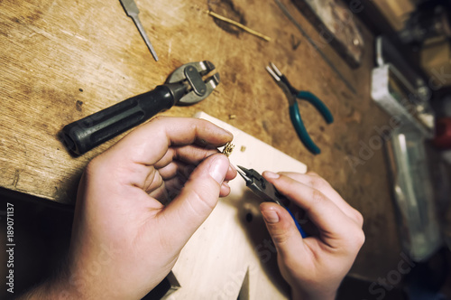 jeweler produces gold jewelry in the workshop