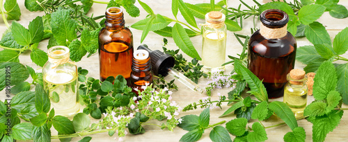 Fototapeta świeże zioła, kwiaty i olejek do masażu na drewnianej desce