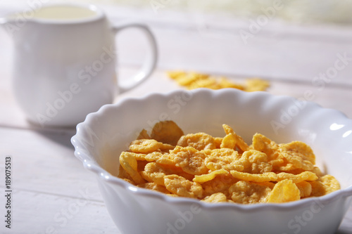 Corn Flakes cereal in a bowl and glass with milk. Morning breakfast.