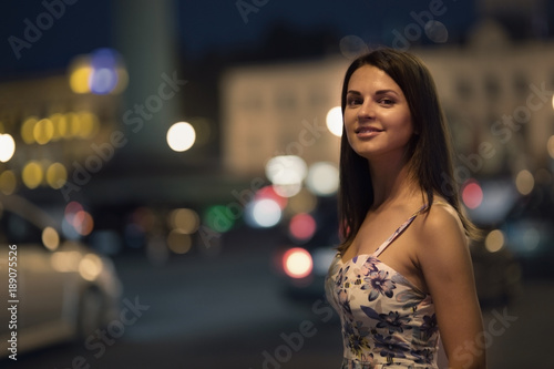 Beautiful woman is walking in the night city.