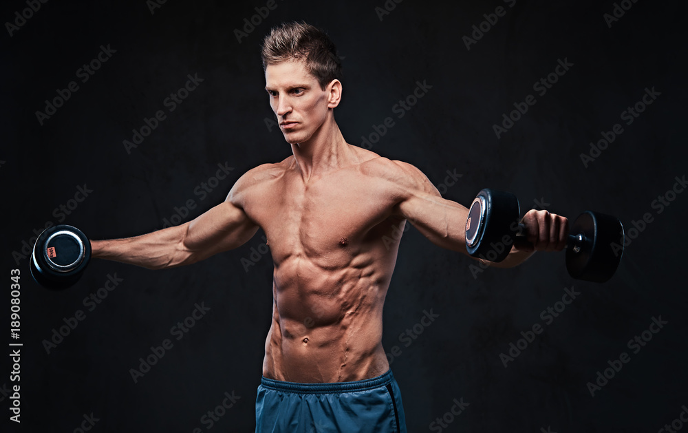 Shirtless athletic male doing shoulders exercises. Shirtless athletic male doing shoulders exercises.