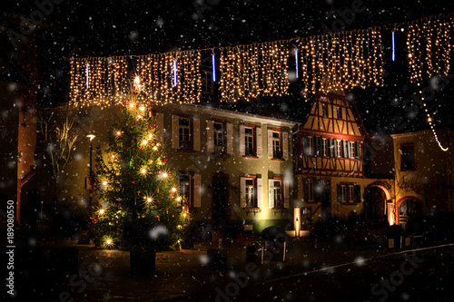Romantic, illuminated Christmas tree during snowfall in the market square of Nierstein