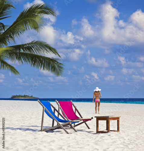 Sch  ner Maledivenstrand mit Model und Sonnenliegen