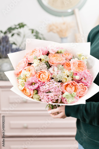 Fototapeta Naklejka Na Ścianę i Meble -  beautiful luxury bouquet of mixed flowers in woman hand. the work of the florist at a flower shop. cute lovely girl