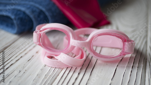 goggles, towel and cap on a wooden table photo