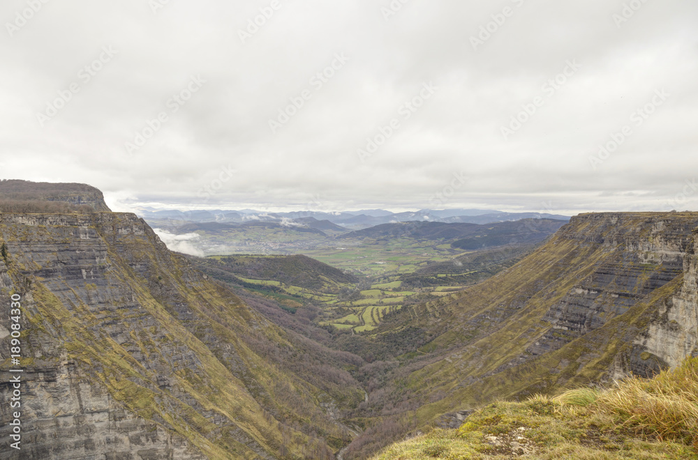 Fototapeta premium Nervion river source, waterfall in the Delika canyon (Alava) on a cloudy day at winter. Basque Country, Spain.