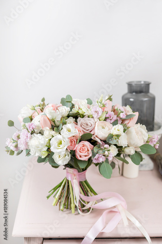 beautiful luxury bouquet of mixed flowers on pink table. the work of the florist at a flower shop. Wedding © malkovkosta