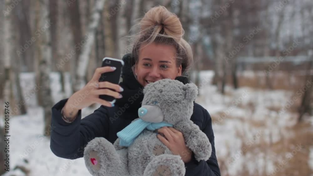 A girl doing selfie in a park with a teddy bear A girl doing selfie in a park with a teddy bear