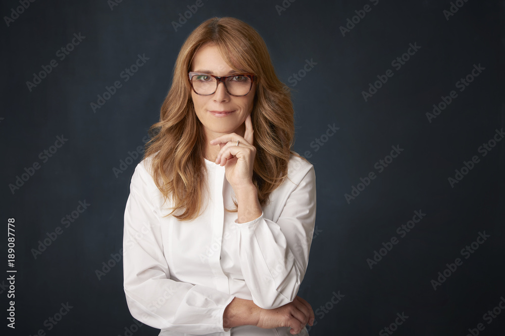 Attractive middle aged woman with toothy smile posing at studio against isolated background Attractive middle aged woman with toothy smile posing at studio against isolated background