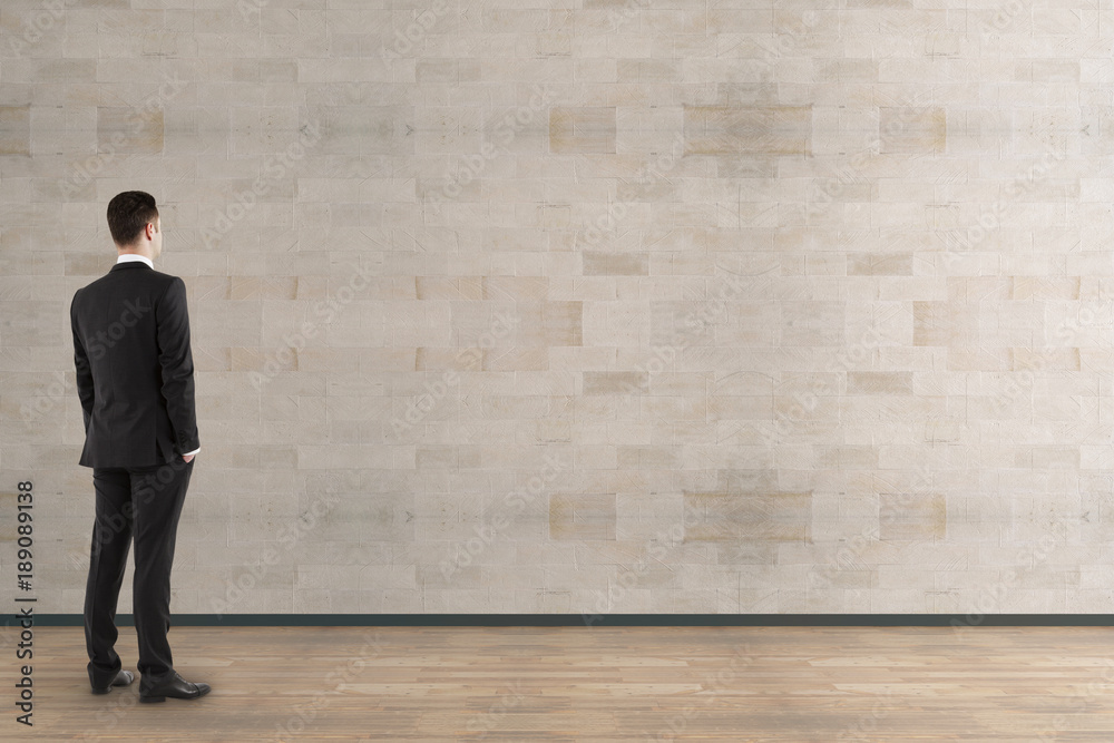 Businessman looking at empty wall Businessman looking at empty wall