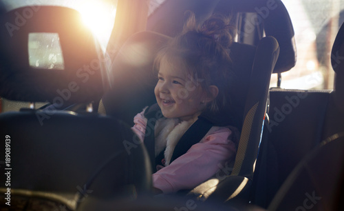 Bilde på lerret car child seat- smiling girl in her car seat.