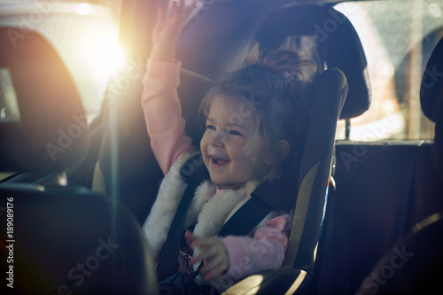 car child seat- happy girl in her car seat. photo